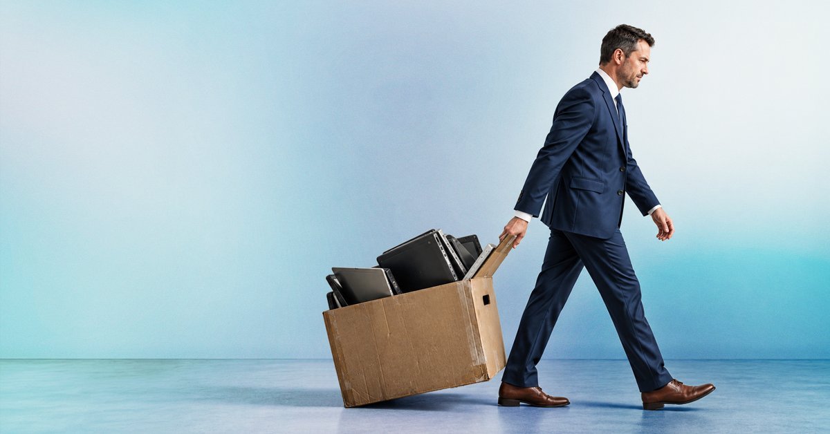 Businessman carrying a box of old laptops